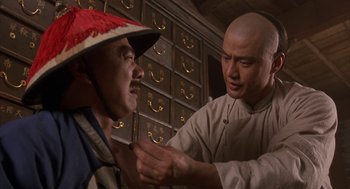 Movie still from “Iron Monkey” (1993), directed by Woo-Ping Yuen – A man is shaving another man's head with an electric razor; Close Up shot, Over the shoulder angle