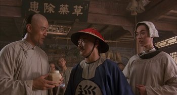 Movie still from “Iron Monkey” (1993), directed by Woo-Ping Yuen – A man with a red hat is holding a cup of coffee; Medium shot, Over the shoulder angle