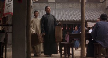 Movie still from “Iron Monkey” (1993), directed by Woo-Ping Yuen – Two men are standing in front of a building; Wide shot, Low angle