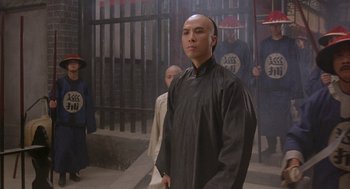Movie still from “Iron Monkey” (1993), directed by Woo-Ping Yuen – A man standing in front of a group of people; Medium shot, Low angle