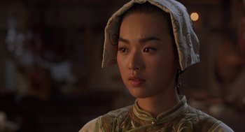 Movie still from “Iron Monkey” (1993), directed by Woo-Ping Yuen – A woman wearing a headscarf and looking at the camera; Close Up shot, Over the shoulder angle