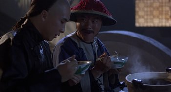 Movie still from “Iron Monkey” (1993), directed by Woo-Ping Yuen – Two men sitting at a dinner table with bowls of food; Close Up shot, Over the shoulder angle
