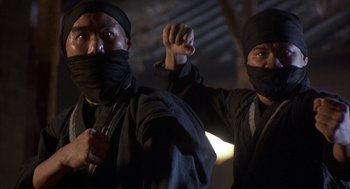 Movie still from “Iron Monkey” (1993), directed by Woo-Ping Yuen – Two men in black clothes and black masks; Medium shot, Low angle