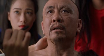 Movie still from “Iron Monkey” (1993), directed by Woo-Ping Yuen – A man with a mustache is looking up at a woman; Close Up shot, Low angle