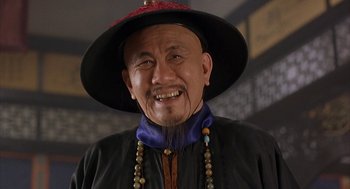 Movie still from “Iron Monkey” (1993), directed by Woo-Ping Yuen – An older man wearing a red hat and a black jacket; Close Up shot, Low angle
