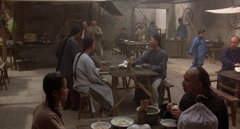 Movie still from “Iron Monkey” (1993), directed by Woo-Ping Yuen – A group of people sitting at a table eating food; Wide shot, High angle
