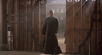 Movie still from “Iron Monkey” (1993), directed by Woo-Ping Yuen – A man standing in front of an open door; Wide shot, Low angle