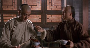 Movie still from “Iron Monkey” (1993), directed by Woo-Ping Yuen – Two men are sitting at a table eating food; Close Up shot, Over the shoulder angle