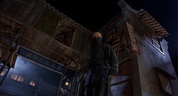 Movie still from “Iron Monkey” (1993), directed by Woo-Ping Yuen – A man standing in front of a building at night; Medium shot, Low angle