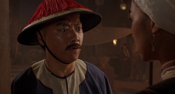 Movie still from “Iron Monkey” (1993), directed by Woo-Ping Yuen – A man wearing a red hat and a blue jacket; Close Up shot, Over the shoulder angle