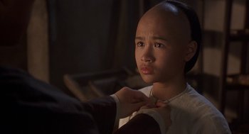Movie still from “Iron Monkey” (1993), directed by Woo-Ping Yuen – A young girl is getting her head shaved by a barber; Close Up shot, Over the shoulder angle