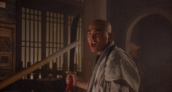 Movie still from “Iron Monkey” (1993), directed by Woo-Ping Yuen – A man holding a baseball bat in his hands; Medium shot, Low angle