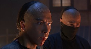 Movie still from “Iron Monkey” (1993), directed by Woo-Ping Yuen – A man with a shaved head and a bandage on his head; Close Up shot, Low angle
