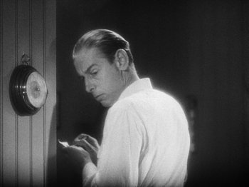 Movie still from “Island of Lost Souls” (1932), directed by Erle C. Kenton – A black and white photo of a man looking at his cell phone; Close Up shot, Low angle