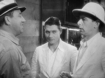 Movie still from “Island of Lost Souls” (1932), directed by Erle C. Kenton – A man in a white suit standing next to two other men; Medium shot, Over the shoulder angle