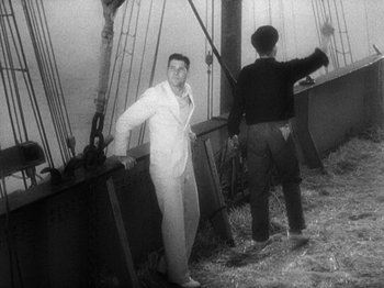 Movie still from “Island of Lost Souls” (1932), directed by Erle C. Kenton – A man standing next to another man on a boat; Medium shot, High angle