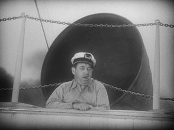 Movie still from “Island of Lost Souls” (1932), directed by Erle C. Kenton – An old photo of a man wearing a sailor's hat; Medium shot, Low angle