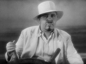 Movie still from “Island of Lost Souls” (1932), directed by Erle C. Kenton – A black and white photo of a man wearing a white hat; Close Up shot, Low angle