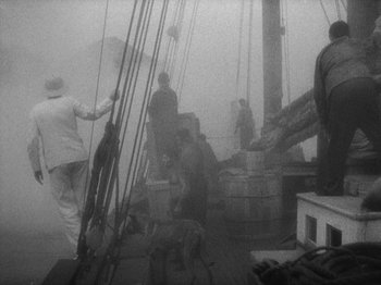 Movie still from “Island of Lost Souls” (1932), directed by Erle C. Kenton – A black and white photo of people on a boat in the fog; Wide shot, High angle