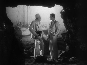 Movie still from “Island of Lost Souls” (1932), directed by Erle C. Kenton – Two men standing next to each other on a beach; Medium shot, High angle