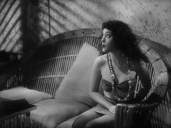 Movie still from “Island of Lost Souls” (1932), directed by Erle C. Kenton – A woman sitting on top of a couch in a living room; Medium shot, Low angle