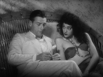 Movie still from “Island of Lost Souls” (1932), directed by Erle C. Kenton – A man and a woman sitting next to each other on a couch; Medium shot, High angle