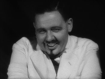 Movie still from “Island of Lost Souls” (1932), directed by Erle C. Kenton – An old photo of a man in a white suit smiling; Close Up shot, High angle