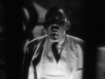 Movie still from “Island of Lost Souls” (1932), directed by Erle C. Kenton – Black and white photograph of a man wearing a suit and tie; Close Up shot, Low angle