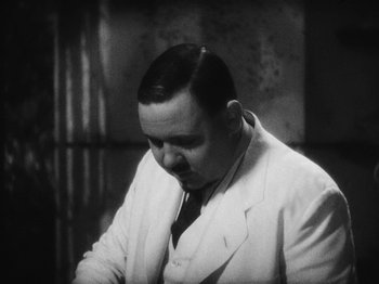 Movie still from “Island of Lost Souls” (1932), directed by Erle C. Kenton – An old photo of a man in a white suit; Close Up shot, High angle