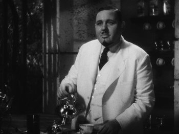 Movie still from “Island of Lost Souls” (1932), directed by Erle C. Kenton – A black and white photo of a man in a suit and tie; Medium shot, Low angle