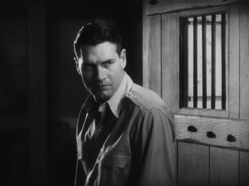 Movie still from “Island of Lost Souls” (1932), directed by Erle C. Kenton – Black and white photograph of a man standing in front of bars; Medium shot, Low angle