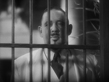 Movie still from “Island of Lost Souls” (1932), directed by Erle C. Kenton – A black and white photo of a man behind bars; Close Up shot, Low angle