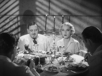 Movie still from “Island of Lost Souls” (1932), directed by Erle C. Kenton – A man and a woman sitting at a dinner table; Medium shot, High angle
