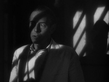 Movie still from “Island of Lost Souls” (1932), directed by Erle C. Kenton – A black and white photo of a man in a white shirt; Close Up shot, Low angle