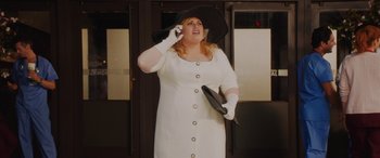 Movie still from “Isn't It Romantic” (2019), directed by Todd Strauss-Schulson – A woman in a white dress talking on a cell phone; Medium shot, Low angle