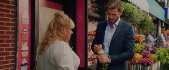 Movie still from “Isn't It Romantic” (2019), directed by Todd Strauss-Schulson – A man and a woman looking at each other in front of a store; Medium shot, Over the shoulder angle