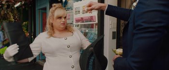 Movie still from “Isn't It Romantic” (2019), directed by Todd Strauss-Schulson – A woman in a white dress and a man in a black suit; Medium shot, Over the shoulder angle