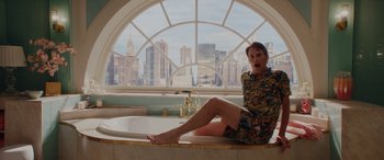 Movie still from “Isn't It Romantic” (2019), directed by Todd Strauss-Schulson – A woman sitting on a bathtub in front of a large window; Medium shot, Overhead angle