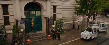Movie still from “Isn't It Romantic” (2019), directed by Todd Strauss-Schulson – Two police officers standing on the side of the street; Extreme Wide shot, High angle