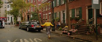 Movie still from “Isn't It Romantic” (2019), directed by Todd Strauss-Schulson – A woman walking down the street with her arms outstretched; Extreme Wide shot, High angle