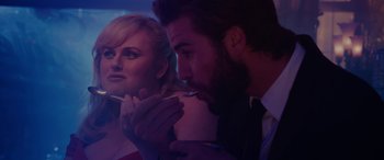 Movie still from “Isn't It Romantic” (2019), directed by Todd Strauss-Schulson – A man and a woman sitting next to each other in a dark room; Close Up shot, Over the shoulder angle