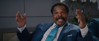 Movie still from “Isn't It Romantic” (2019), directed by Todd Strauss-Schulson – A person wearing a suit and tie; Close Up shot, Over the shoulder angle