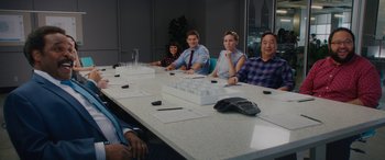 Movie still from “Isn't It Romantic” (2019), directed by Todd Strauss-Schulson – A group of people sitting around a table; Medium shot, Over the shoulder angle