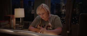 Movie still from “Isn't It Romantic” (2019), directed by Todd Strauss-Schulson – A woman is writing on a piece of paper; Medium shot, Over the shoulder angle
