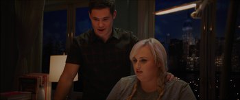 Movie still from “Isn't It Romantic” (2019), directed by Todd Strauss-Schulson – A man standing next to a woman in front of a window; Close Up shot, Over the shoulder angle