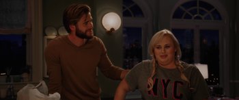 Movie still from “Isn't It Romantic” (2019), directed by Todd Strauss-Schulson – A man and a woman standing next to each other in a room; Medium shot, Over the shoulder angle