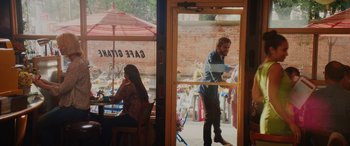 Movie still from “Isn't It Romantic” (2019), directed by Todd Strauss-Schulson – A man and a woman are standing at a table in front of a window; Wide shot, Over the shoulder angle