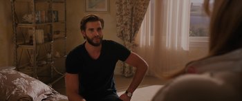 Movie still from “Isn't It Romantic” (2019), directed by Todd Strauss-Schulson – A man sitting on the floor in front of a window; Medium shot, Over the shoulder angle