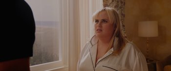 Movie still from “Isn't It Romantic” (2019), directed by Todd Strauss-Schulson – A woman standing in front of a window wearing a white robe; Close Up shot, Over the shoulder angle