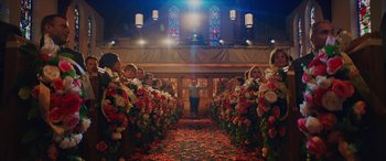 Movie still from “Isn't It Romantic” (2019), directed by Todd Strauss-Schulson – A group of people standing in a room with flowers; Extreme Wide shot, High angle